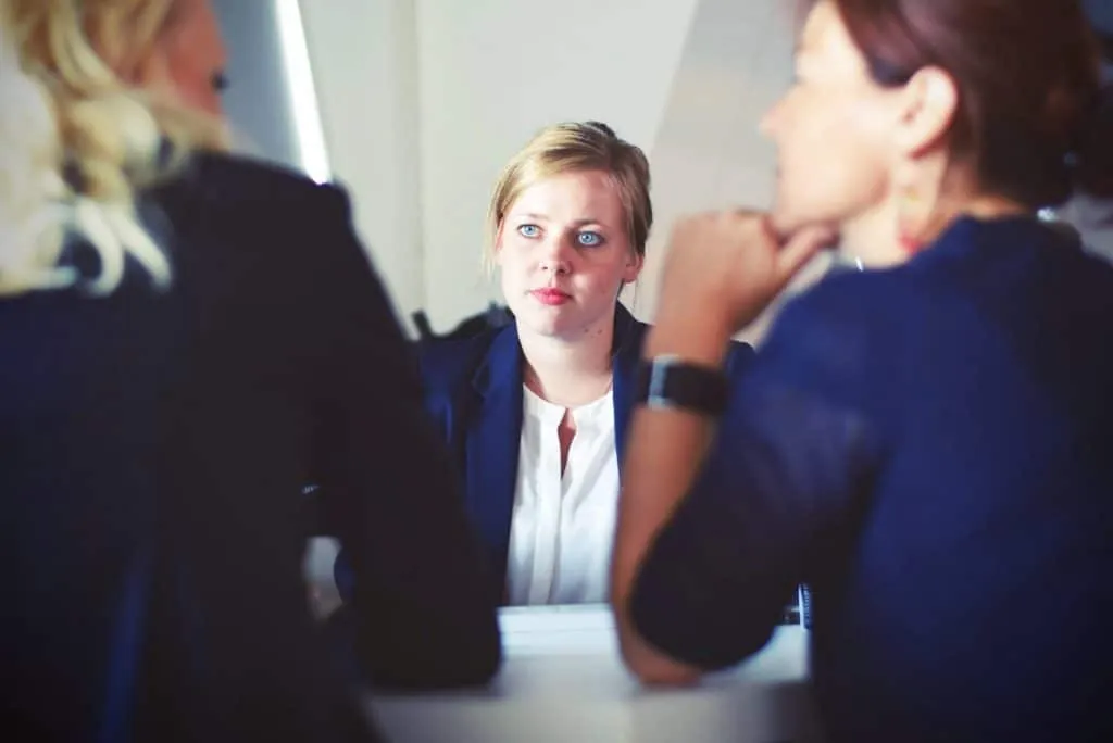 Trois femmes d'affaires en réunion, une au centre écoute attentivement